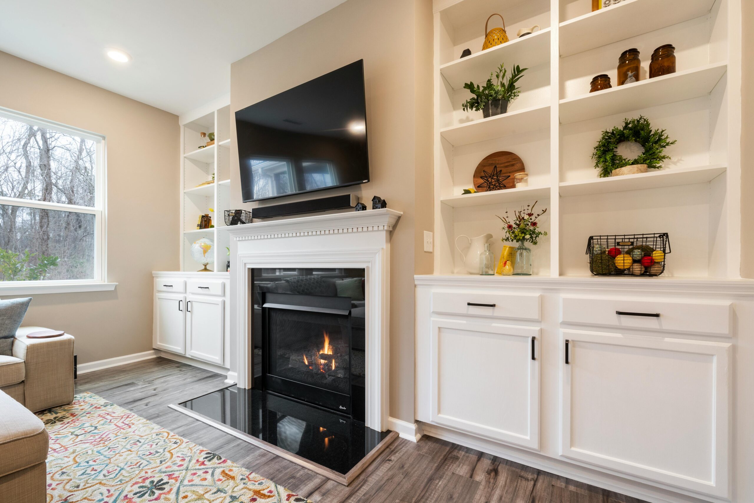 A luxury living room featuring a modern fireplace and built-in shelves with tasteful decor in Bucks County, PA