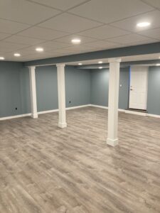 Luxury basement renovation with hardwood floors, custom wood beams, and modern lighting fixtures in Doylestown, Pennsylvania