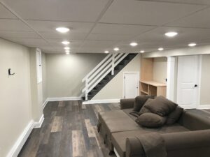 Luxury basement renovation with hardwood floors, custom under-stair storage, and modern lighting fixtures in Doylestown, Pennsylvania