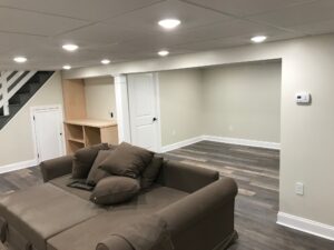 Luxury basement renovation with hardwood floors, custom under-stair storage, and modern lighting fixtures in Doylestown, Pennsylvania