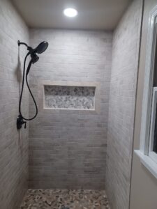 Modern standing shower bathroom remodel by Visionary Custom Creations featuring dual vanity, custom tile walls and floors, and a luxury shower in Bucks County, Pennsylvania.