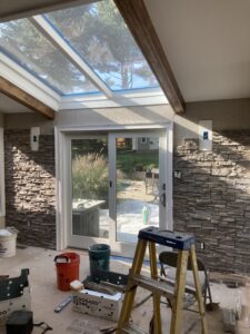 Luxury sunroom remodel with stone walls, custom wood beams, skylight, and sliding glass doors in Montgomeryville, Pennsylvania