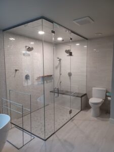 Luxury bathroom remodel with large glass shower, custom tile, built-in seating and shelving, and designer lighting in Solebury, Pennsylvania