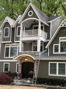 Front-facing home renovation with Cape Cod-style gabled arches, custom balconies, new siding, large windows, and detailed trim in Washington Crossing, Pennsylvania