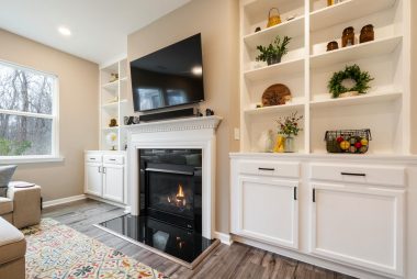 A luxury living room featuring a modern fireplace and built-in shelves with tasteful decor in Bucks County, PA